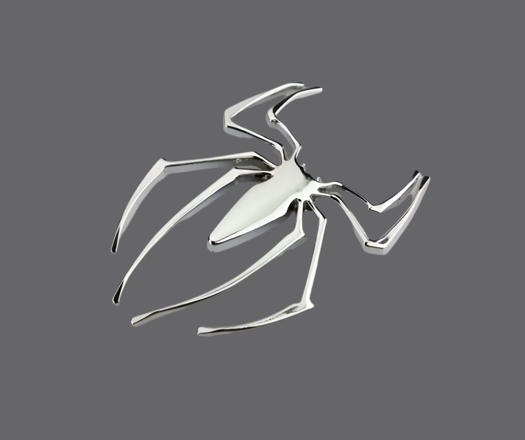 Metallic spider emblem on a white background